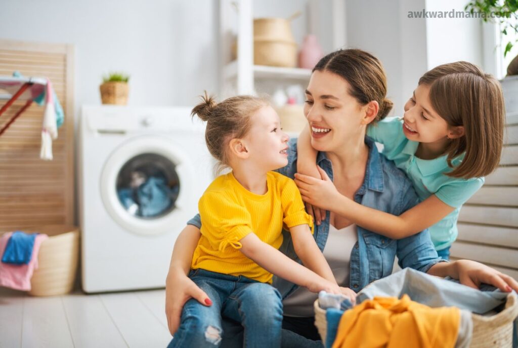 Mom teaching her two young daughters how to help with laundry as part of learning family routines