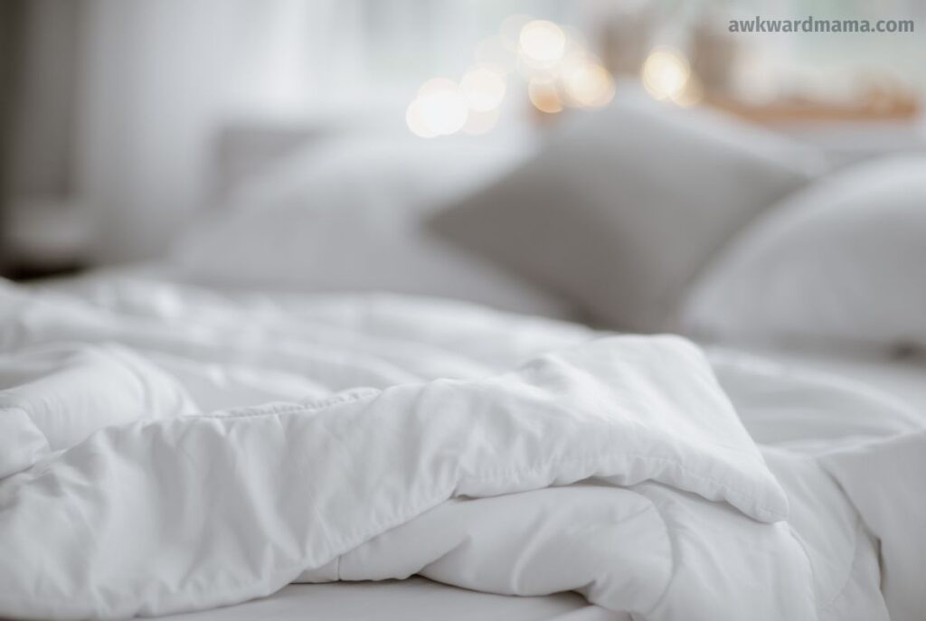 Softly lit bed and pillows representing rest and recovery on low-energy days