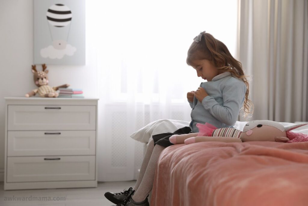 Young girl getting dressed in the morning as part of a stress-free school routine