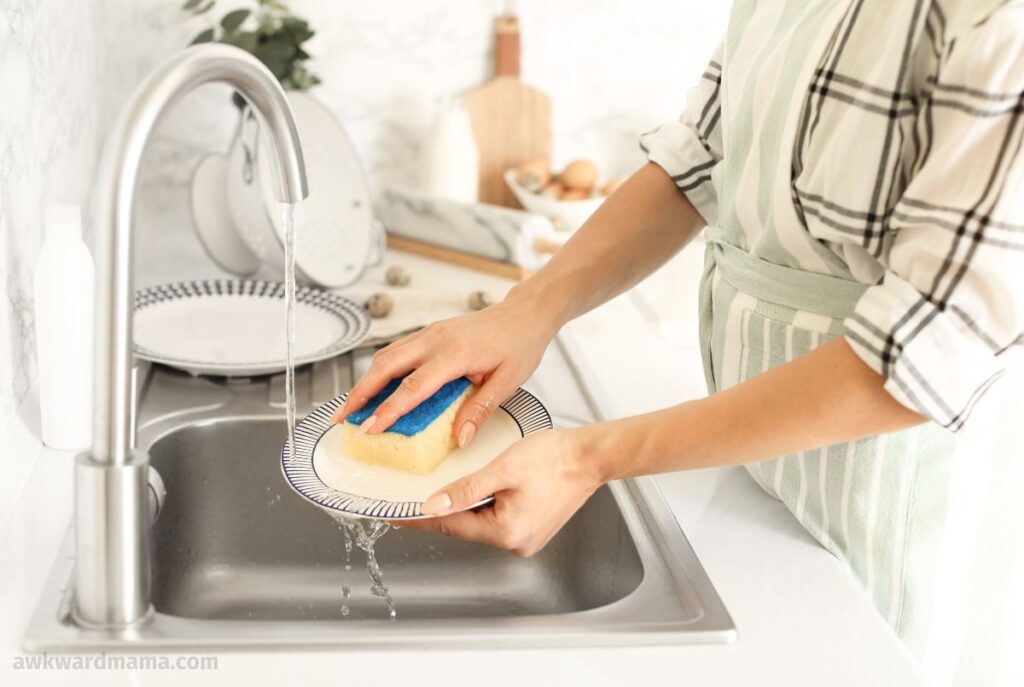 Hands washing dishes in the kitchen sink as part of a quick evening prep routine for moms
