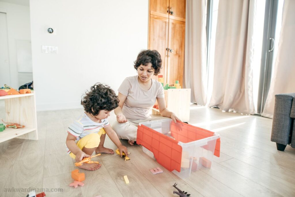 Mom and her child cleaning and organizing toys together as part of a shared family chore system