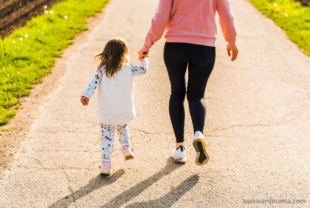 Mom walking outside with child during a short midday reset break to recharge energy